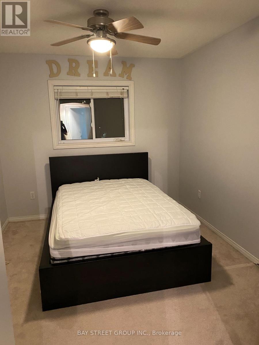 A bedroom with a bed, a window, and a ceiling fan.