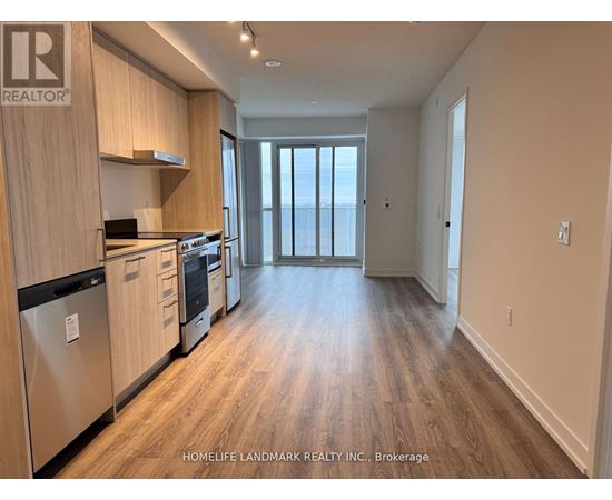 A kitchen with wooden cabinets and a stainless steel refrigerator.