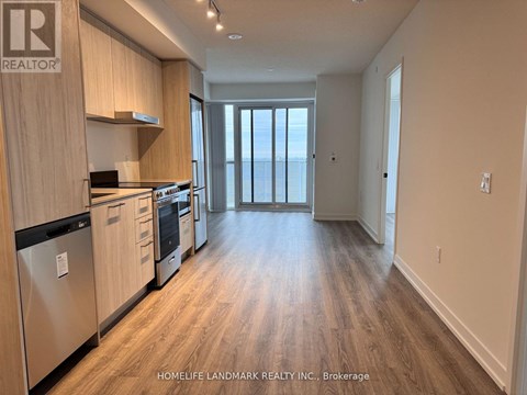 A kitchen with wooden cabinets and a stainless steel refrigerator.