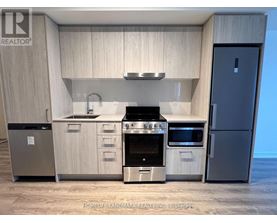 A modern kitchen with a stainless steel refrigerator and a stove top oven.