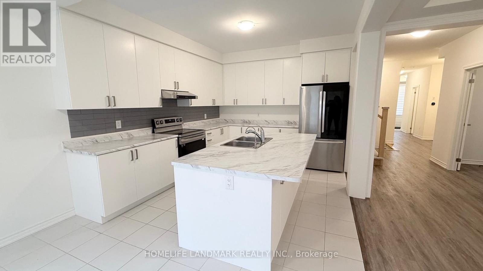 A kitchen with white cabinets and a black countertop is on the market.