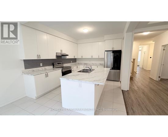 A kitchen with white cabinets and a black countertop is on the market.