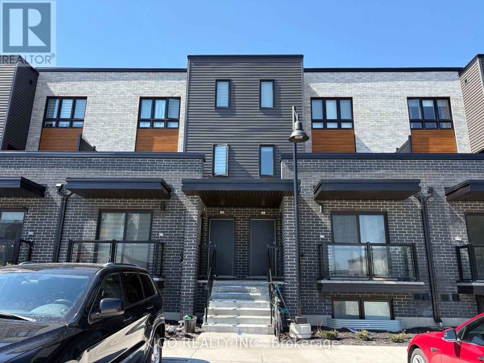 A modern apartment building with cars parked in front.