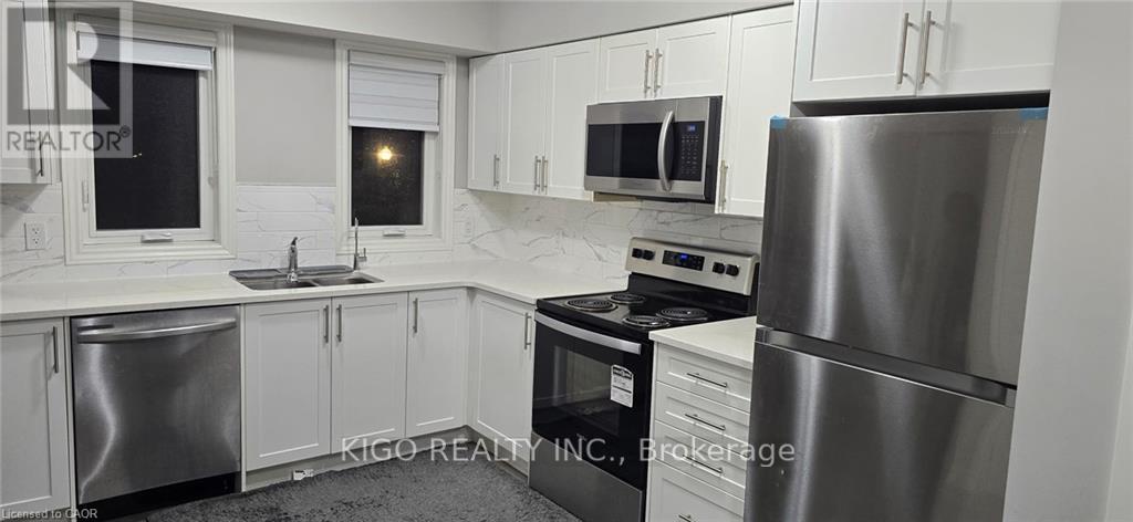 A kitchen with white cabinets and stainless steel appliances.
