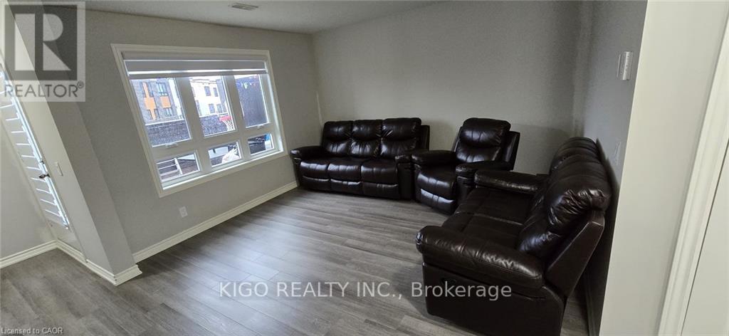 A living room with black leather couches and a window.