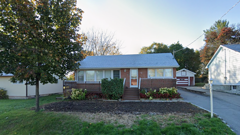 A house with a front yard and a tree.