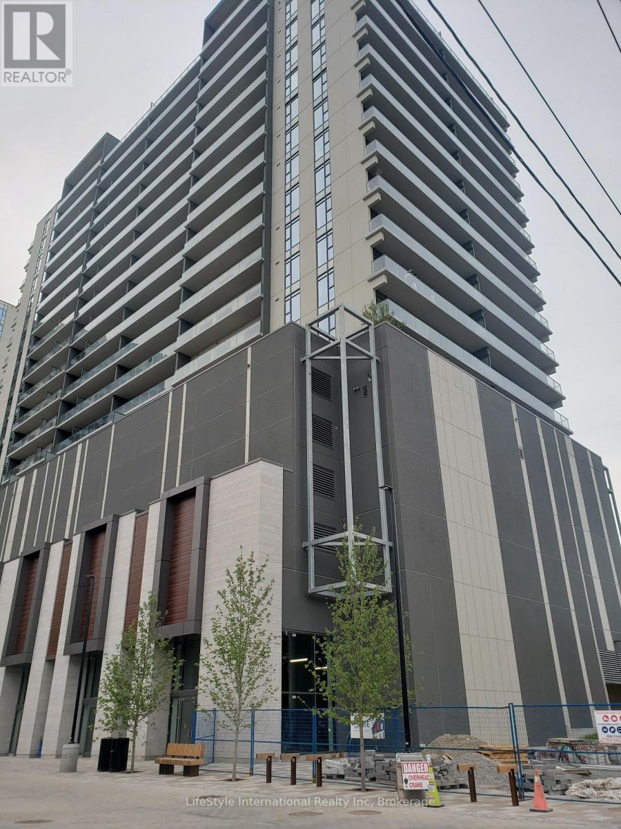 A tall building with a grey facade and a sign that reads "REALTOR" on the top left corner.