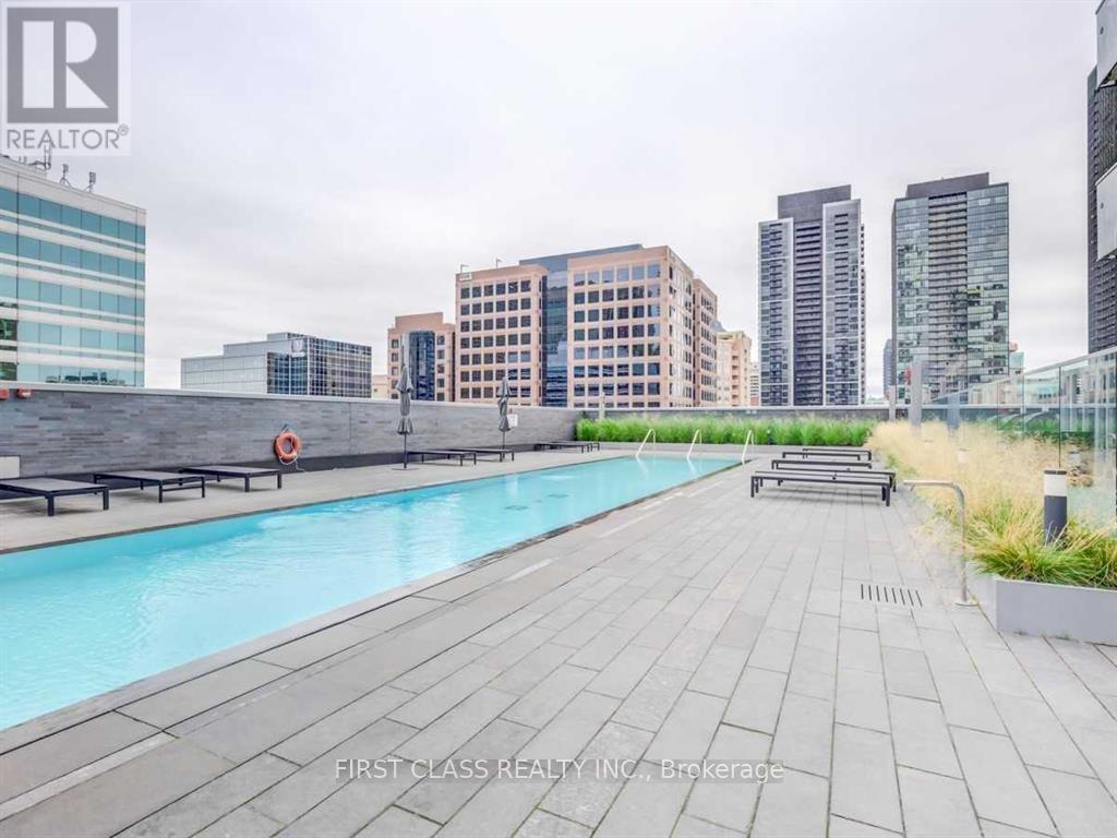 A swimming pool on a rooftop with a city skyline in the background.