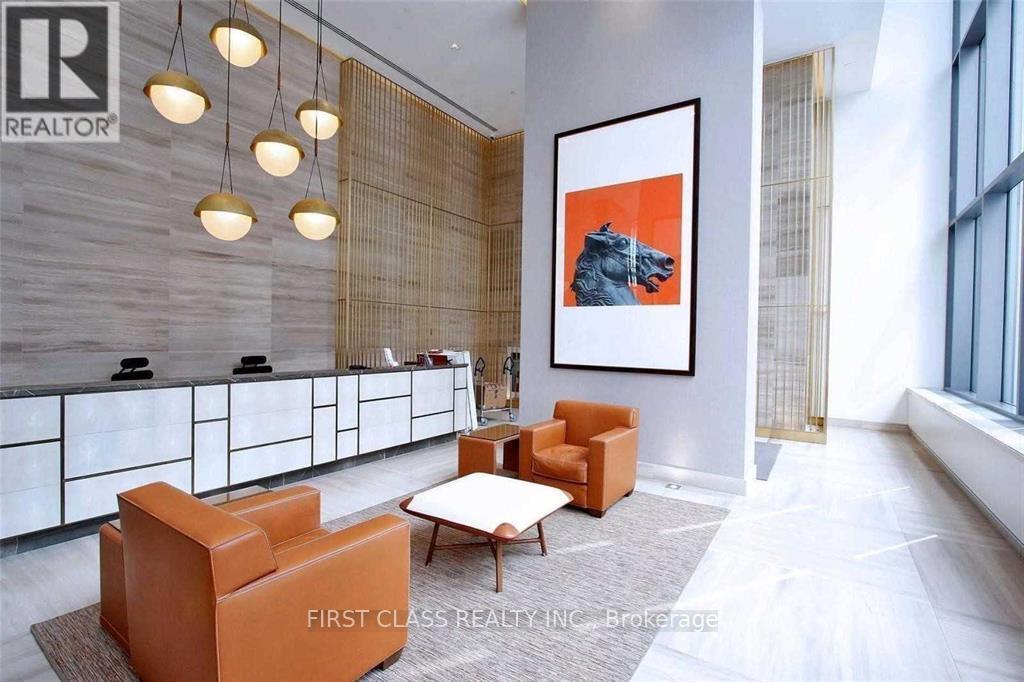 A modern office space with a large painting and orange chairs.