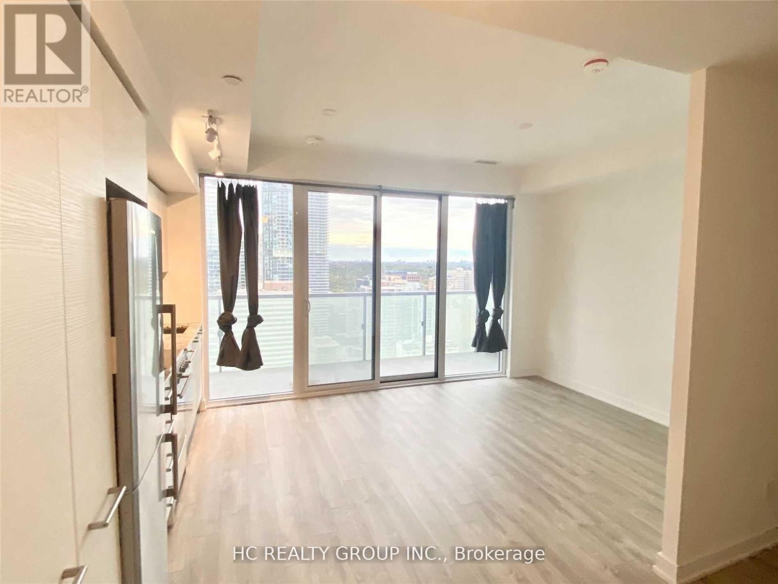 A spacious room with a view of the city through large windows.