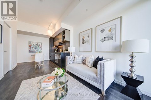A living room with a white couch and a glass coffee table.