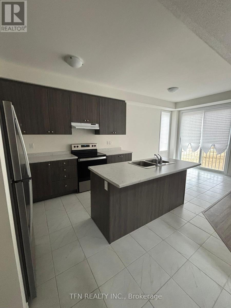 A kitchen with a refrigerator, sink, and stove.