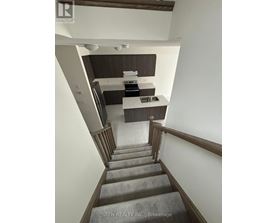 A staircase leads to a kitchen area.