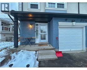 A blue house with a white garage door and a red flag on the ground.