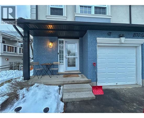 A blue house with a white garage door and a red flag on the ground.
