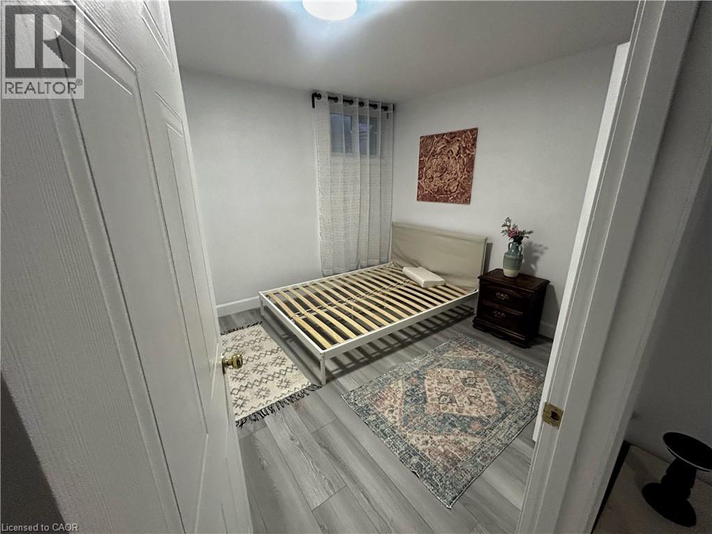 A bedroom with a bed, a rug, and a picture on the wall.
