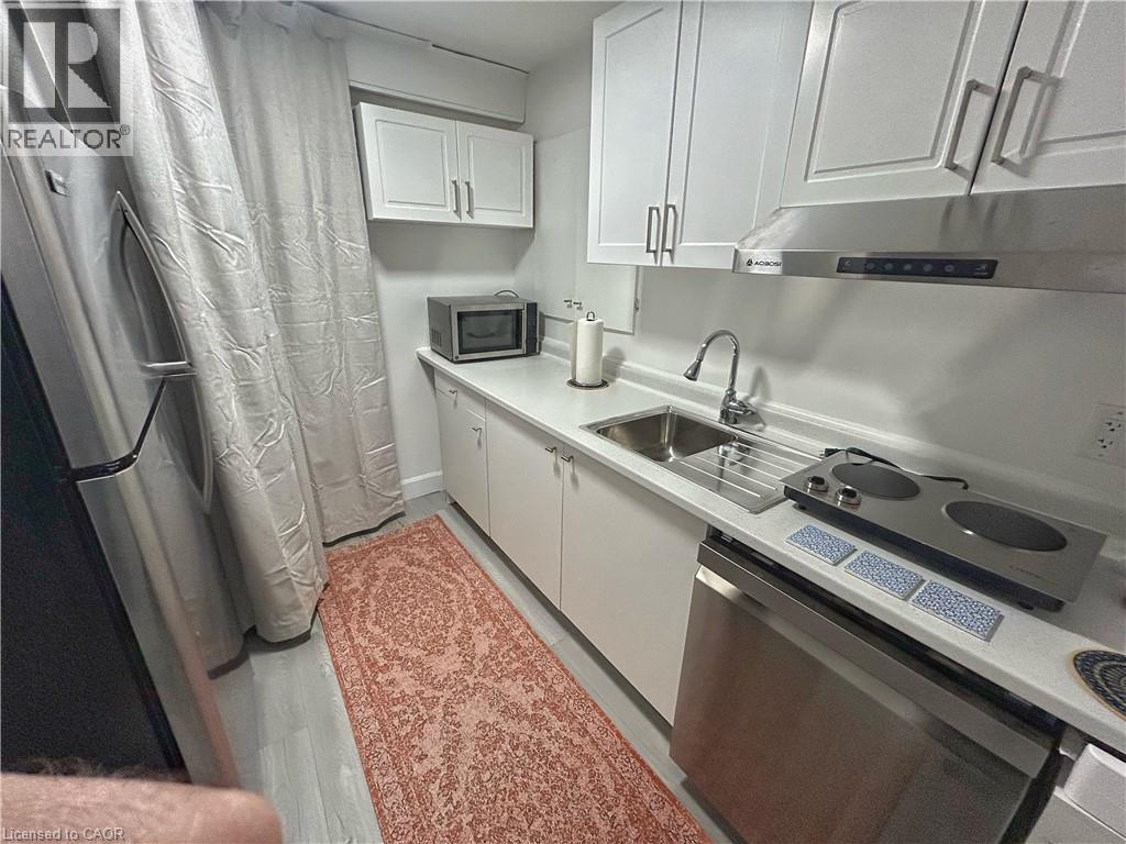 A small kitchen with a sink, stove, and microwave.