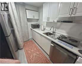 A small kitchen with a sink, stove, and microwave.
