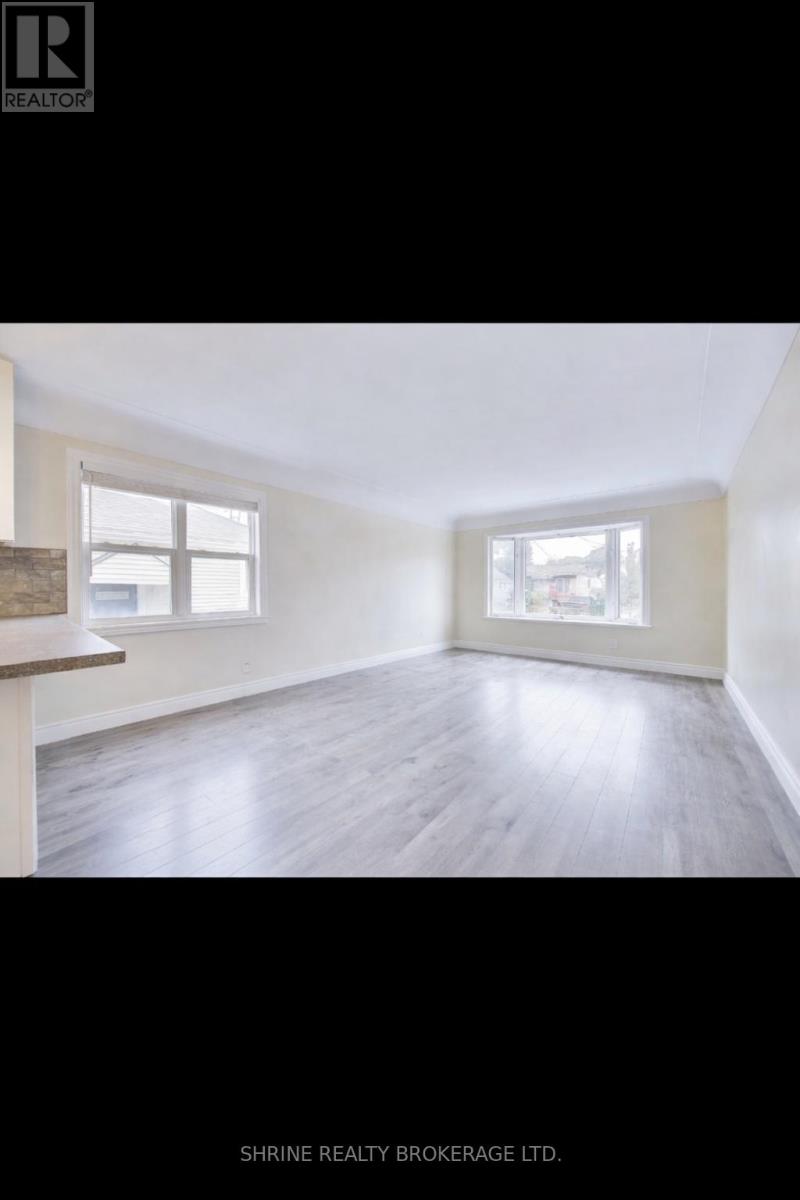 A room with a window and a wooden floor.