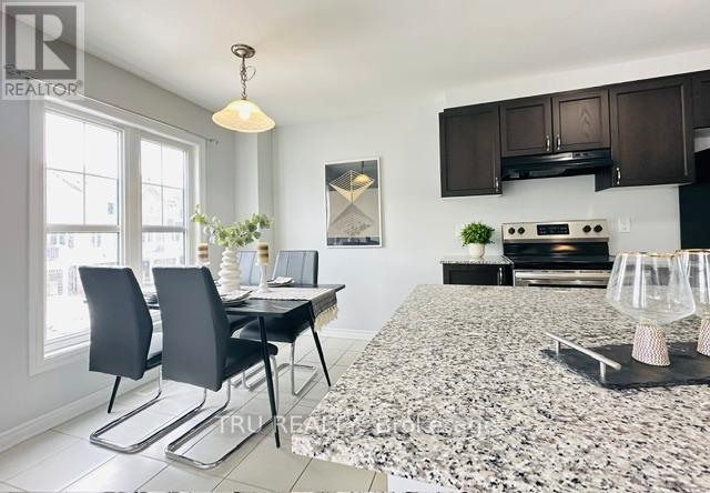 A modern kitchen with granite countertops and a dining area with a table and chairs.