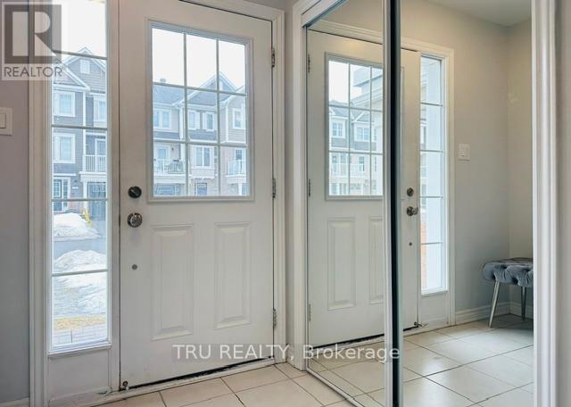 A white door with a glass window showing a building across the street.