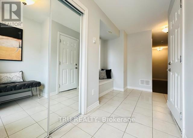 A hallway with white walls and a glass door leading to a bedroom.