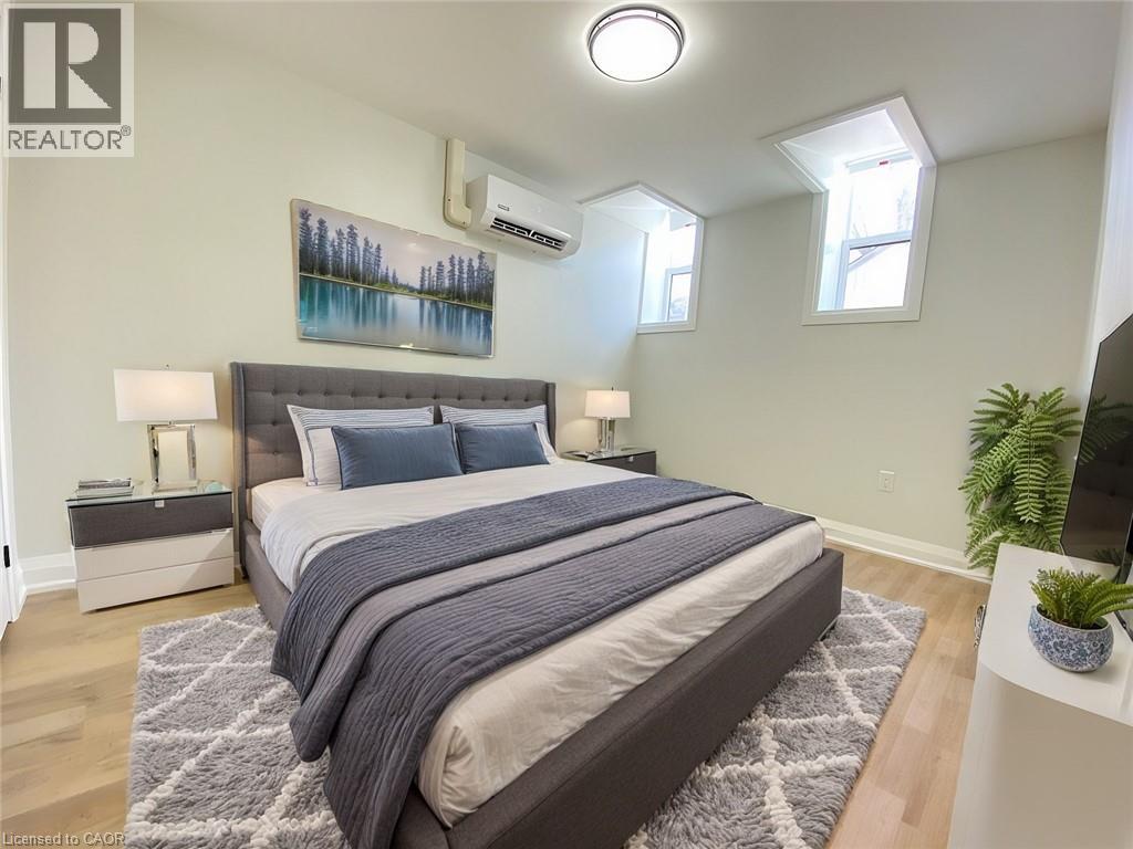 A bedroom with a large bed and a painting on the wall.