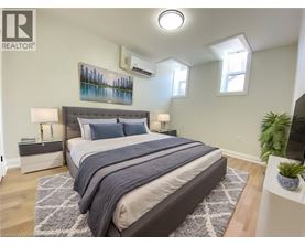 A bedroom with a large bed and a painting on the wall.