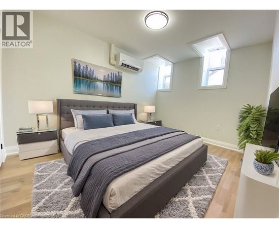 A bedroom with a large bed and a painting on the wall.