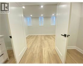 A room with wooden flooring and white walls.