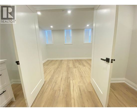 A room with wooden flooring and white walls.