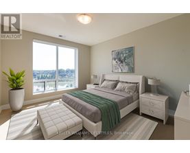 A bedroom with a large bed, a nightstand, and a window overlooking a cityscape.