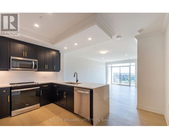 A modern kitchen with black cabinets and stainless steel appliances.