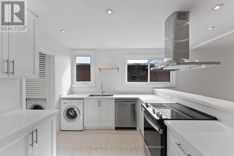 A modern kitchen with white cabinets and stainless steel appliances.