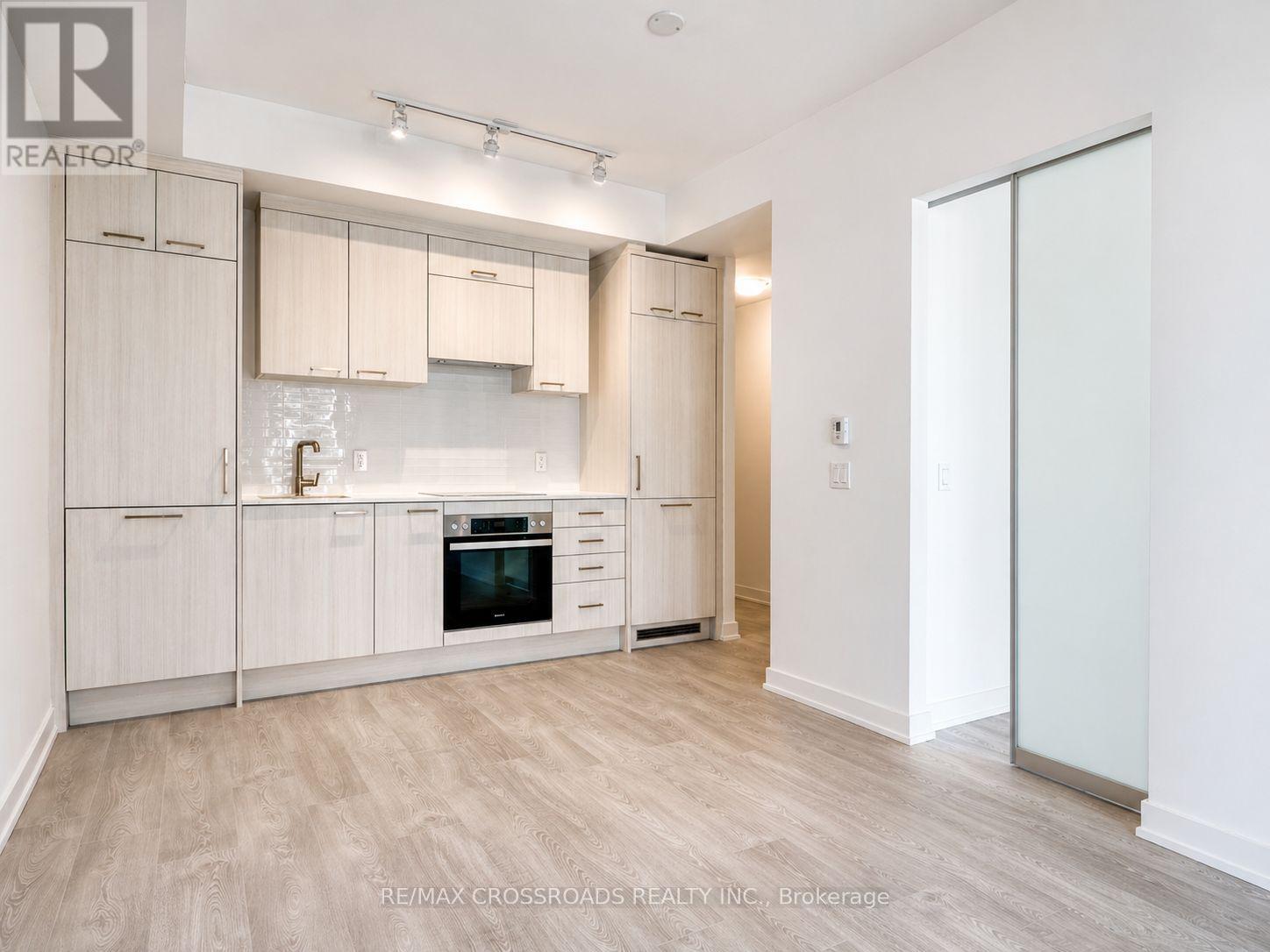 A spacious room with a sliding glass door leading to a balcony.