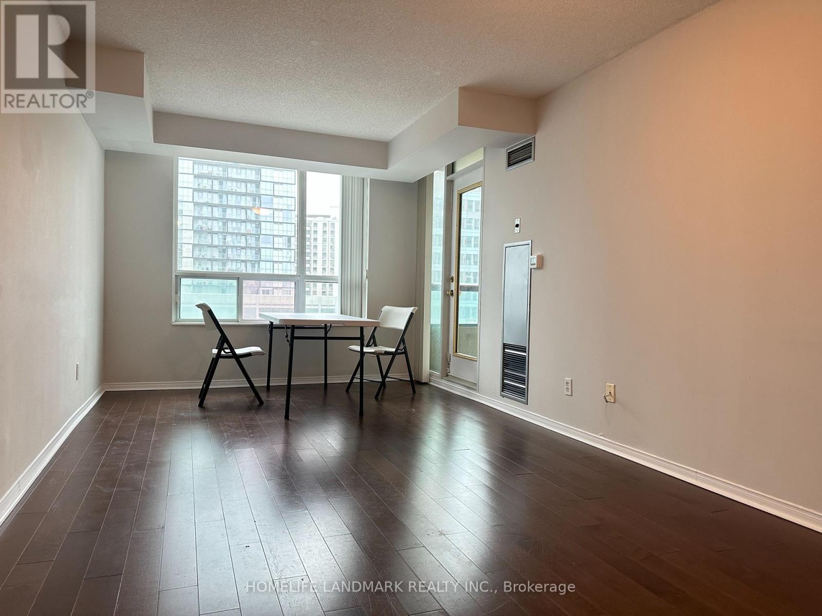 A room with a table and chairs in front of a window.