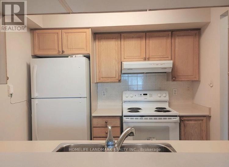 A kitchen with wooden cabinets and a white stove top oven.