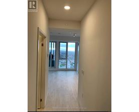 A hallway with a view of the city through the glass doors.