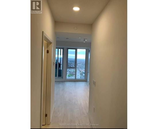 A hallway with a view of the city through the glass doors.