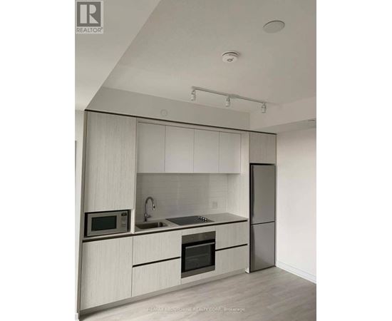 A modern kitchen with white cabinets and stainless steel appliances.