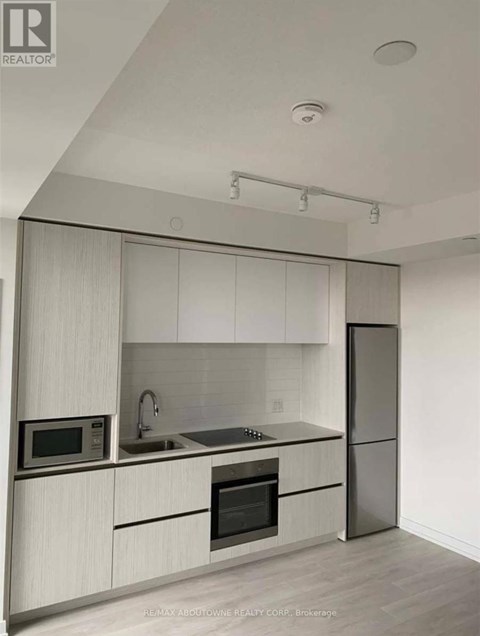 A modern kitchen with white cabinets and stainless steel appliances.