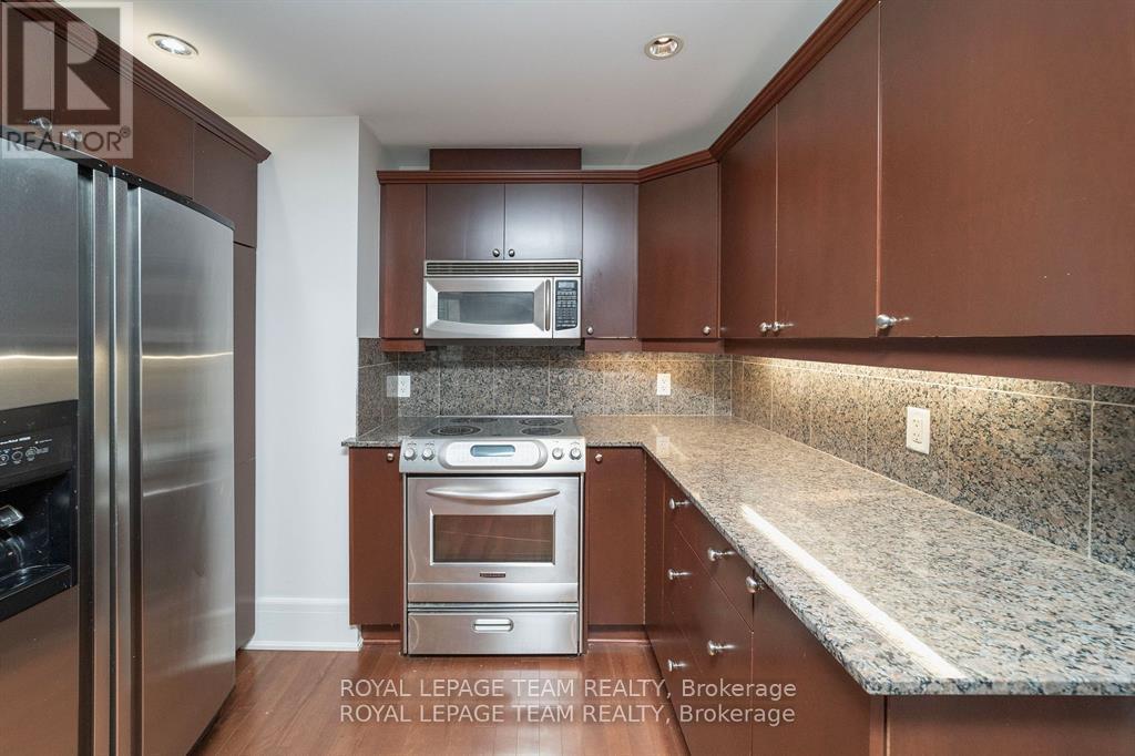 A kitchen with brown cabinets and a granite countertop.