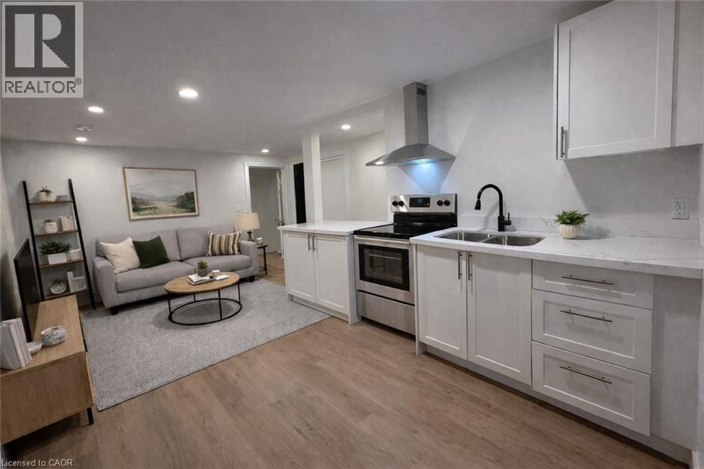 A modern kitchen with white cabinets and a wooden floor.