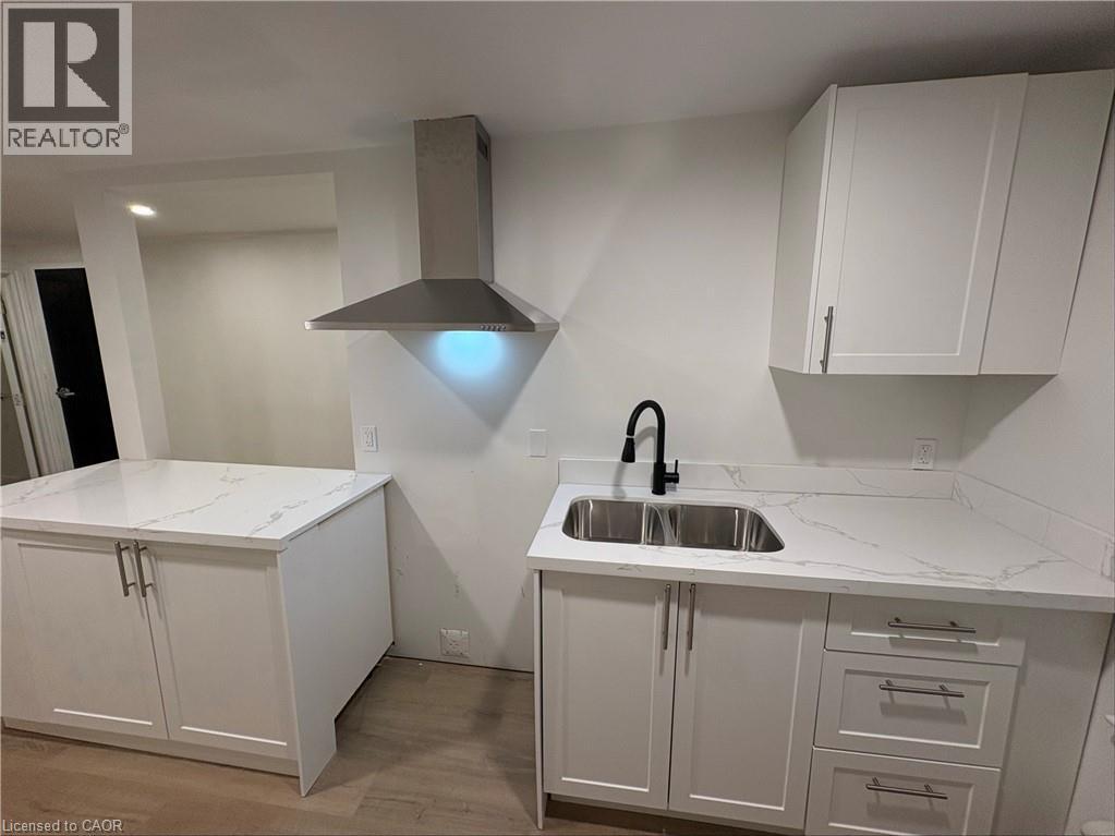 A kitchen with white cabinets and a marble countertop.