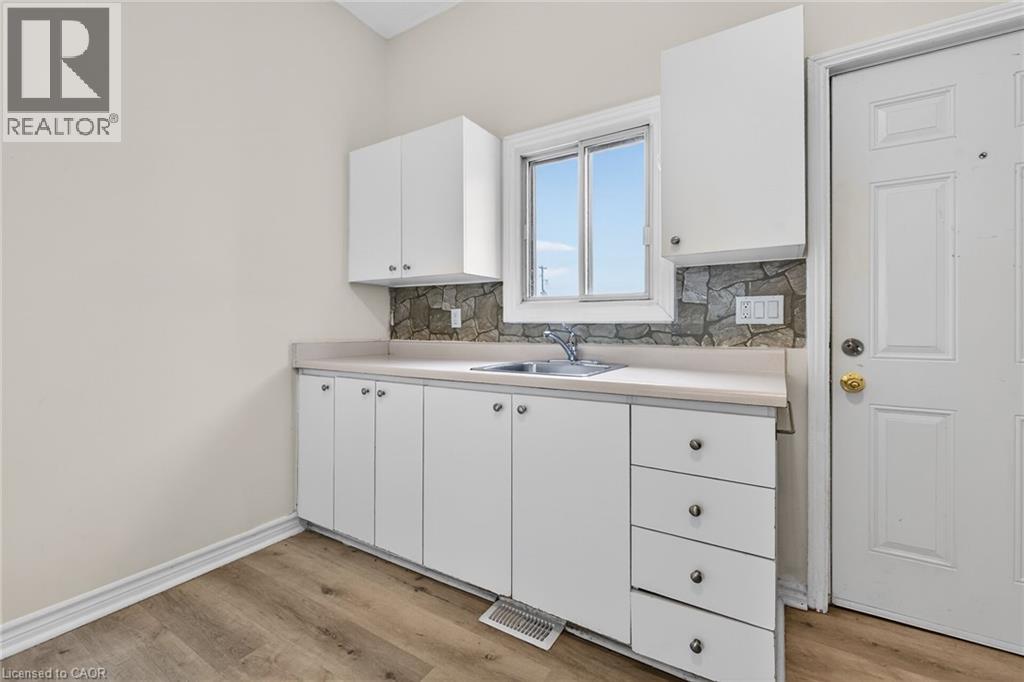 A white kitchen with a sink and cabinets.