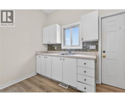 A white kitchen with a sink and cabinets.