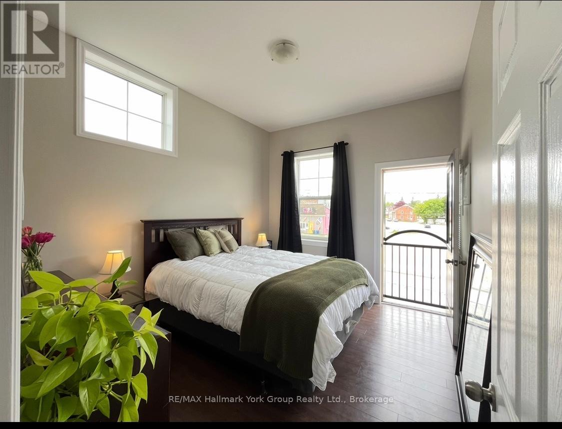 A bedroom with a large bed and a balcony.