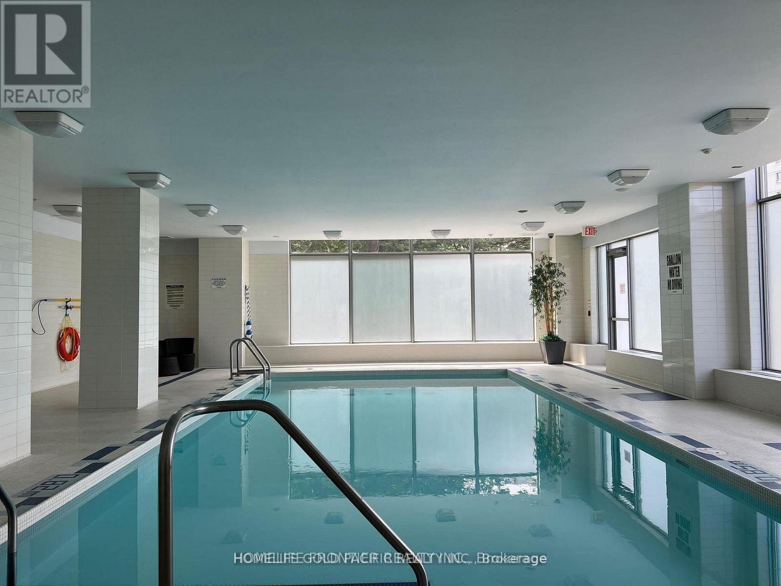 A large indoor swimming pool with a glass barrier.