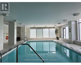 A large indoor swimming pool with a glass barrier.