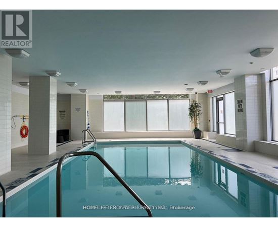 A large indoor swimming pool with a glass barrier.